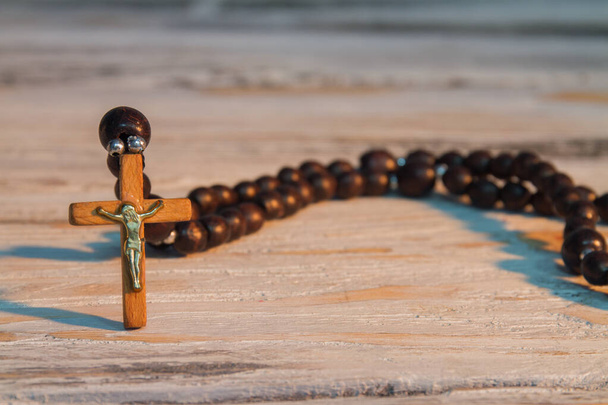 Sacred brown wooden rosary with jesus crucifix. - 写真・画像