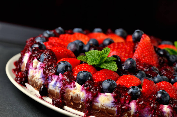 frische Erdbeeren, Blaubeeren und Kirschtorte. dunkler Hintergrund. geringe Schärfentiefe - Foto, Bild