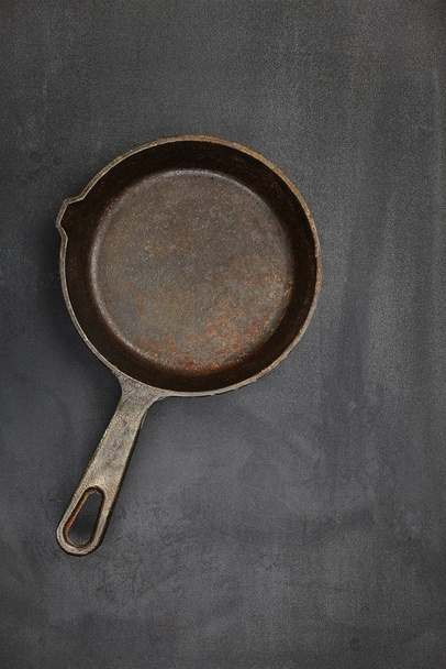 Clean empty old retro pan on black kitchen table. Top view. Close up. - 写真・画像