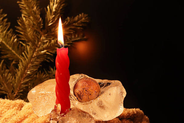 Décoration de Noël et Nouvel An. Bougie rouge brûlante avec de la glace sur un fond sombre. Bonne humeur pendant les vacances en famille. Design artistique pour les vacances d'hiver. Lumière chaude
 - Photo, image
