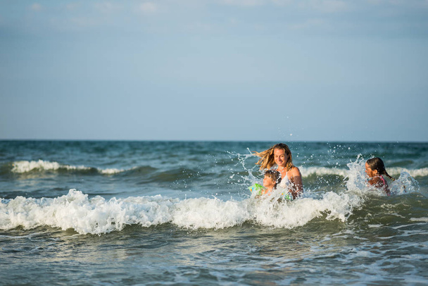 Cheerful young mother swims in the sea - Photo, Image