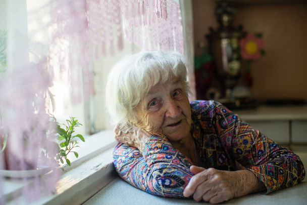 Retrato de mulher idosa sentada na cozinha
. - Foto, Imagem