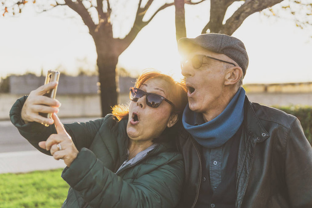 Nyugdíjas pár élvezi a szabad időt, hogy vicces szelfi - közép-a - Fotó, kép