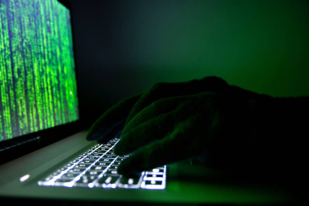 Hacker steals information using a laptop.  - Foto, afbeelding