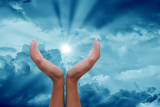 Les mains féminines autour du soleil dans un ciel nuageux
 - Photo, image