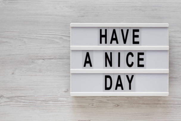 'Have a nice day' words on a lightbox on a white wooden surface, - Foto, Bild