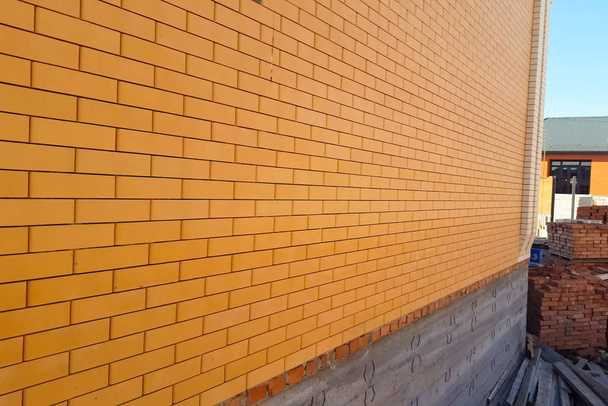 σπίτι είναι κατασκευασμένο από κίτρινο πυριτικό τούβλο. Οι τοίχοι και η πρόσοψη του σπιτιού είναι φτιαγμένοι από τούβλα. - Φωτογραφία, εικόνα