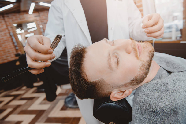 Парикмахерский процесс бритья бородатый хипстер в парикмахерской - Фото, изображение