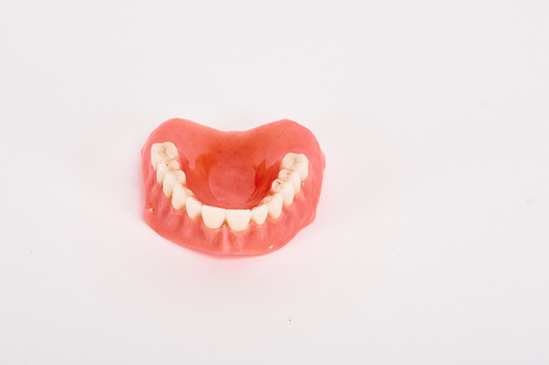 偽の売春婦歯科衛生士の検査の概念。上顎の完全な取り外し可能なプラスチック製の入れ歯. - 写真・画像