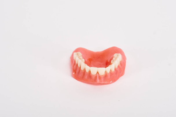 偽の売春婦歯科衛生士の検査の概念。上顎の完全な取り外し可能なプラスチック製の入れ歯. - 写真・画像