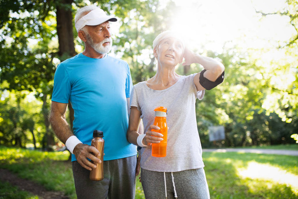 Senior couple jogging and running outdoors in park nature - Fotoğraf, Görsel