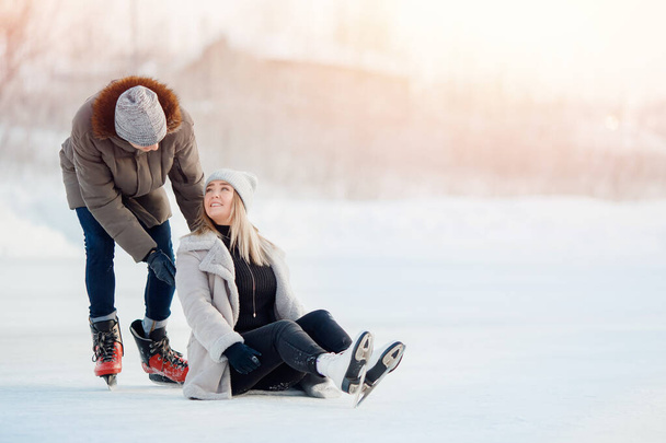 女の子ショー男どこ彼女持っています痛み後に秋傷害上のアイススケートリンクで冬 - 写真・画像