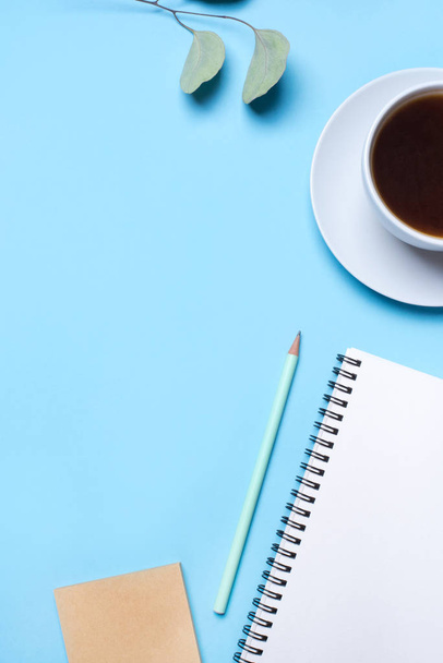 Blue background with notepad, pencil and cup of coffee. - Фото, зображення