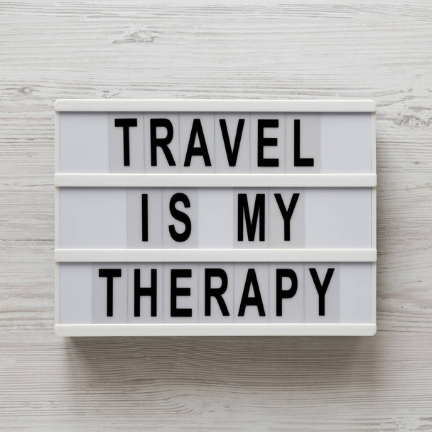 "Το ταξίδι είναι η θεραπεία μου" λέξεις σε ένα σύγχρονο πίνακα σε ένα λευκό ξύλινο - Φωτογραφία, εικόνα