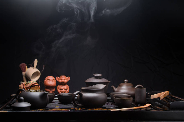 Set da tè cinese su un tavolo nero con vapore. Incredibile rituale asiatico di preparazione del tè. Cina, tè, stoviglie, bollitore, tradizione, salute, cerimonia del tè, vigore, energia, Asia
, - Foto, immagini