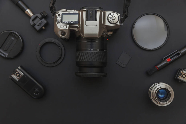 Photographer workplace with dslr camera system, camera cleaning kit, lens and camera accessory on dark black table background. Hobby travel photography concept. Flat lay top view copy space. - Photo, Image