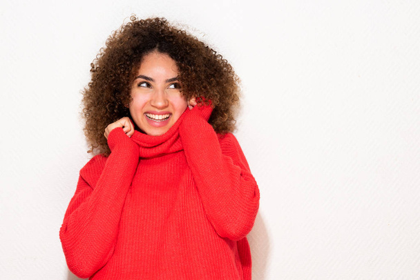 Ritratto felice giovane donna afro-americana che tiene il maglione e distoglie lo sguardo
 - Foto, immagini