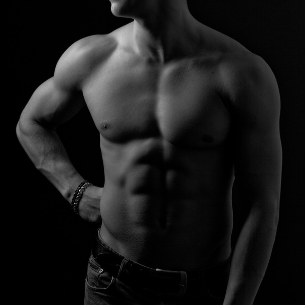 Perfect male body on black background. - 写真・画像