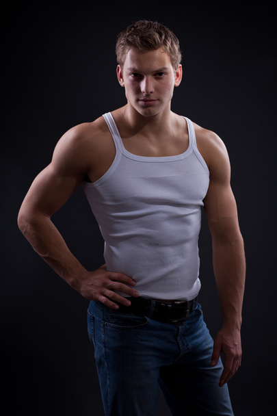 Sexy young man wearing white undershirt and jeans - 写真・画像