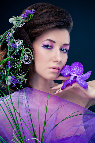 Beauty girl with orchid flowers and professional makeup - Φωτογραφία, εικόνα