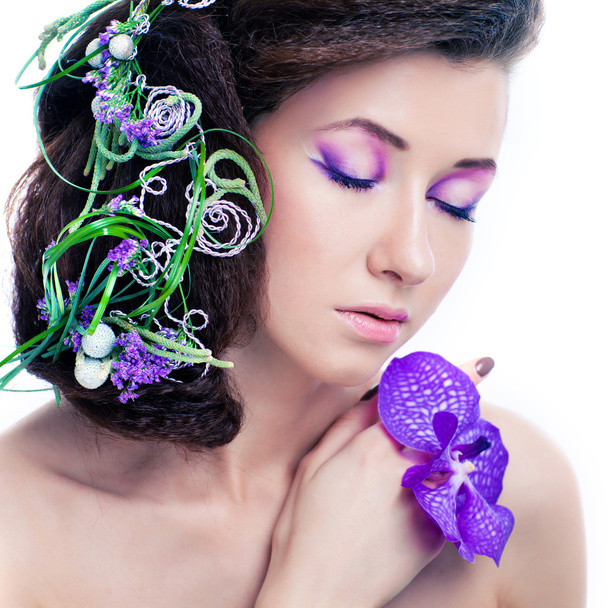 Beauty girl with orchid flowers and professional makeup - Fotó, kép