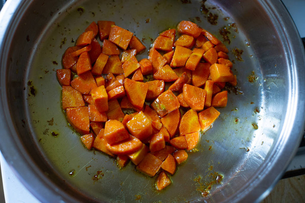 Hortalizas cortadas en cubos fritos en sartén, en cocina. La zanahoria frito en cubos en una sartén. Zanahoria
 - Foto, Imagen