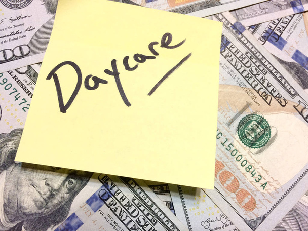 Soldi americani in contanti e posta gialla nota con il testo Daycare
 - Foto, immagini
