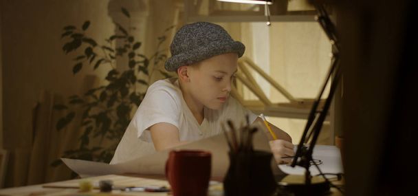 Mladý umělec kreslí u stolu - Fotografie, Obrázek