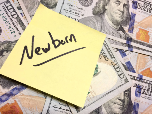 Американські готівкові гроші і жовтий лист з текстом Newborn - Фото, зображення