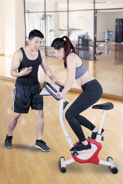 Woman riding a spinning exercise bike at gym - Foto, Bild