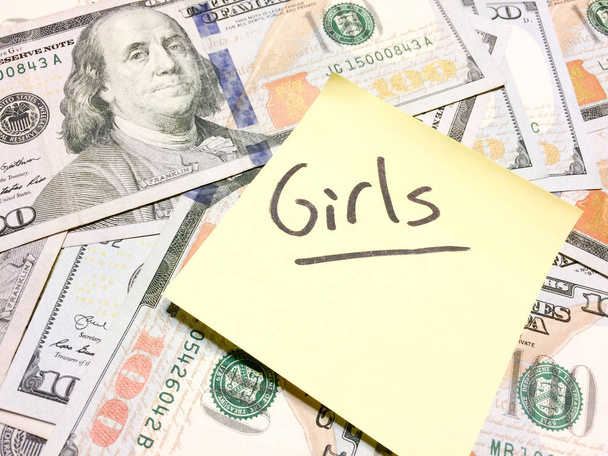 Americké peníze v hotovosti a žlutá samolepící bankovka s textem Dívky - Fotografie, Obrázek