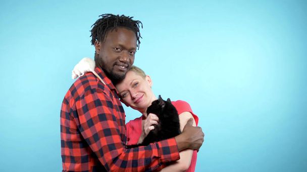  African male and a Caucasian woman . holding a black cat and a white rat.  - Photo, Image