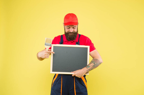 Future profession. builder man paint on blackboard. bearded worker with painting brush. Construction worker ready to work. hipster craftsman advertisement. copy space. professional repairer wanted - Fotó, kép
