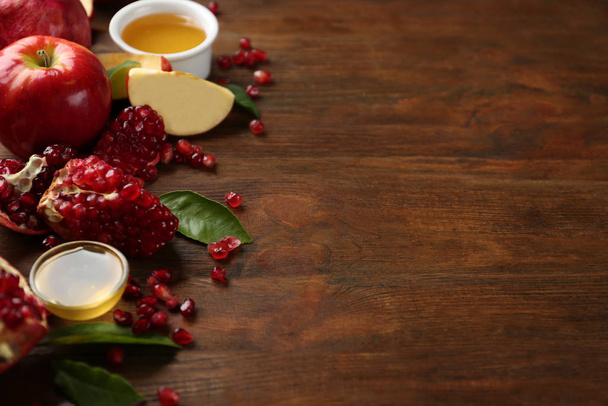 Honey, apples and pomegranate on wooden table, space for text. Rosh Hashanah holiday - Photo, image