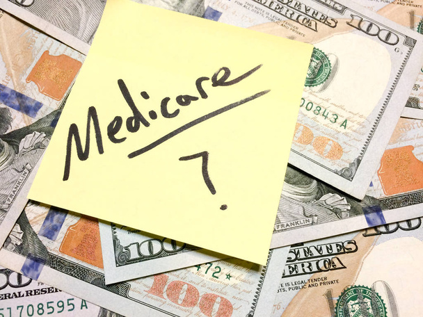 Amerikkalainen käteistä rahaa ja keltainen tahmea huomautus tekstiä Medicare kysymysmerkillä
 - Valokuva, kuva