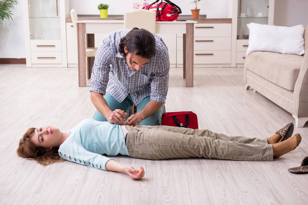 Young couple in first aid concept at home - Foto, immagini