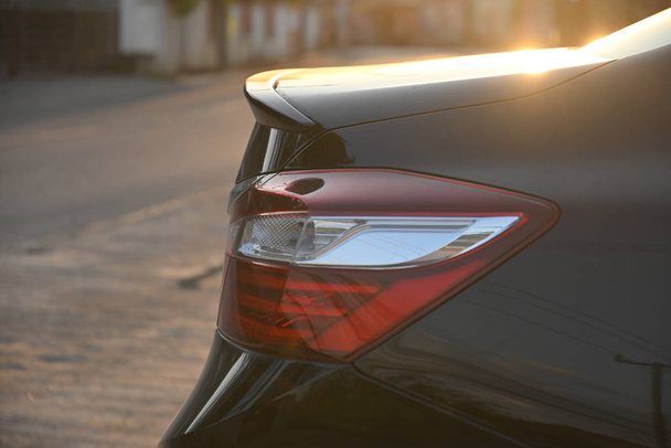 Крупный план заднего фонаря черного современного автомобиля в утренней сцене
 - Фото, изображение