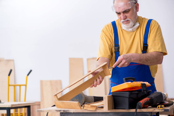 Viejo carpintero trabajando en taller - Foto, imagen