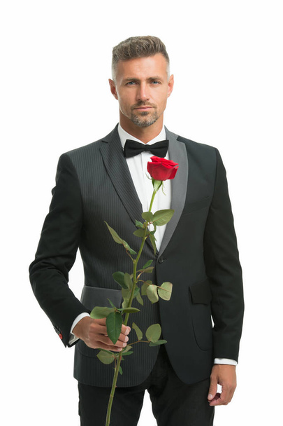 tuxedo man with rose flower. happy valentine day. special occasion. male formal style of clothing. elegant man in suit and tie sexy man on romantic date. Black tie dress code for evening events - Фото, изображение