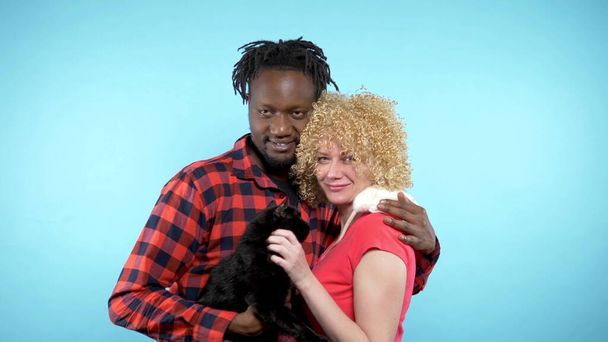  African male and a Caucasian woman . holding a black cat and a white rat.  - Fotografie, Obrázek