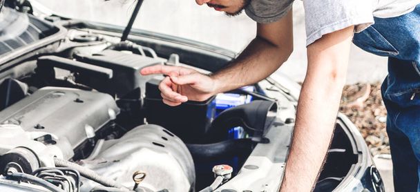 Professional car mechanic in uniform  fixing a car engine and re - Photo, Image