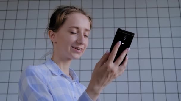 Femme utilisant un smartphone, ayant un chat vidéo, une interview ou une consultation - Séquence, vidéo