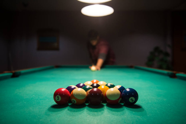 Male lines up the cue ball to break in a game of billiard - Photo, Image