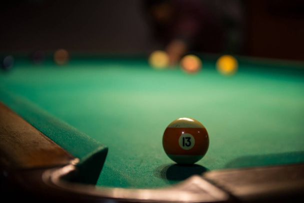 Male lines up billiard shot to sink a ball by the corner pocket - Foto, immagini