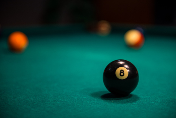 Close -up of billiard 8 ball on billiard table with other balls in the background - Foto, Imagen