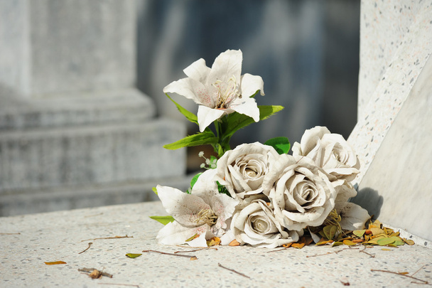 Old white fake flower on grave - Foto, afbeelding