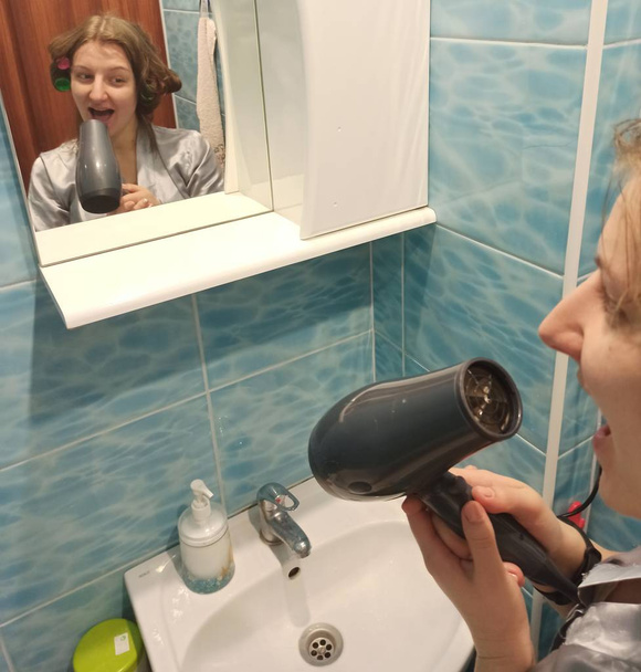 Mujer europea cantando con secador de pelo en el baño
 - Foto, imagen