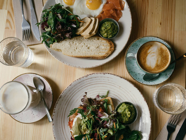 Breakfast top view table. Bread, eggs, salmon and salad leaves. Coffee time. Enjoy your meal!  - 写真・画像
