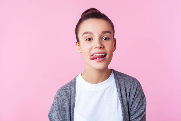 Portrait of carefree childish brunette girl showing tongue, diso - Φωτογραφία, εικόνα