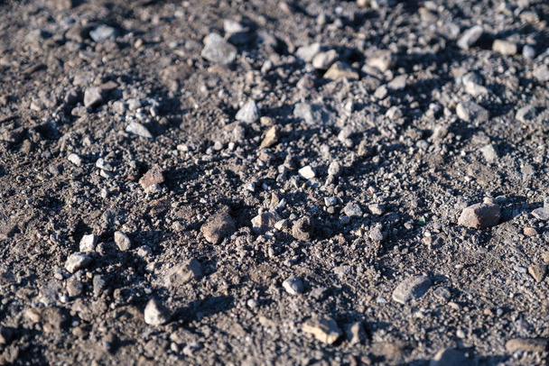 Különböző méretű kövek fekszenek egy poros felületen. Földút a t során - Fotó, kép